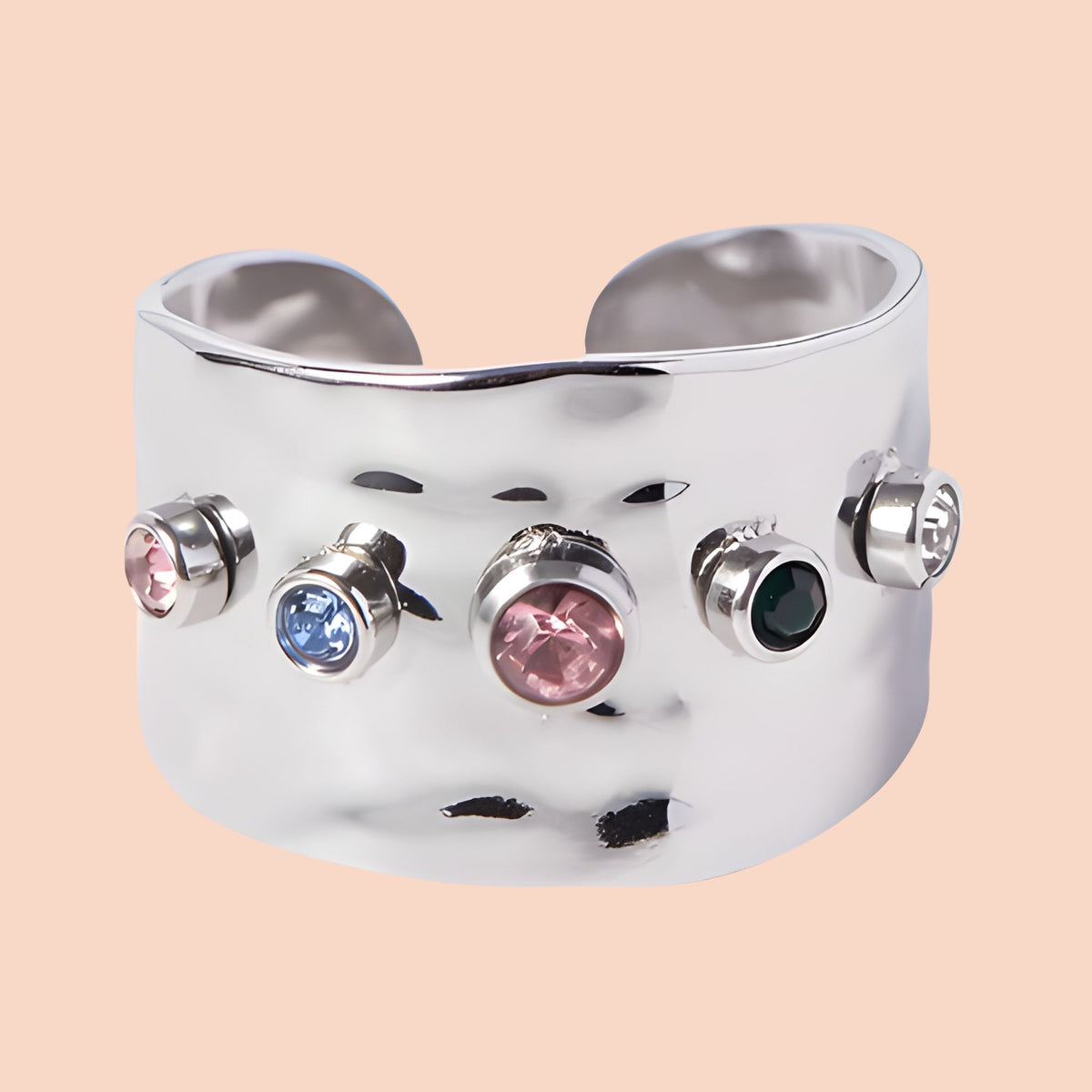 Silver ring with colorful gemstones on a beige background