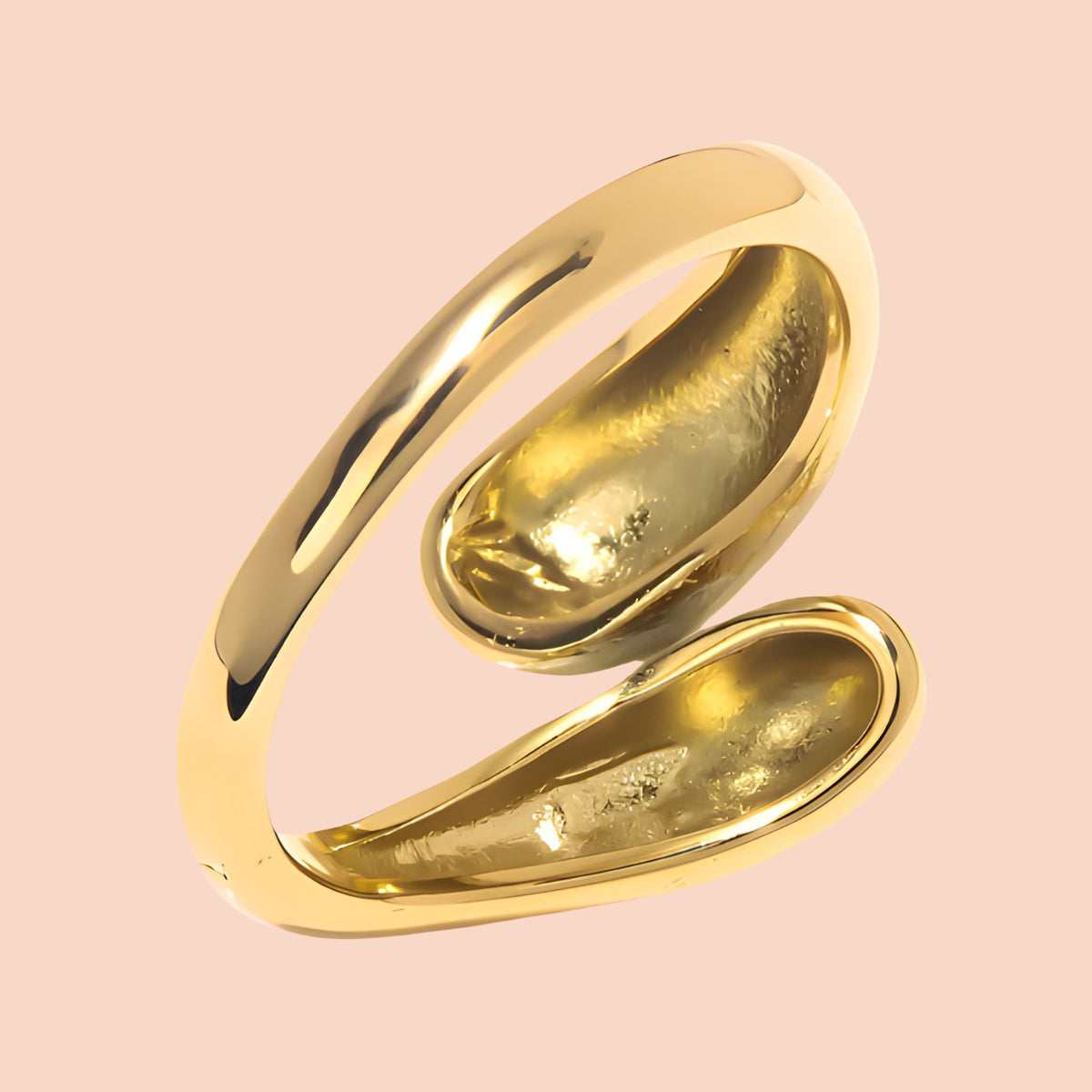 Gold ring with a unique design on a pink background