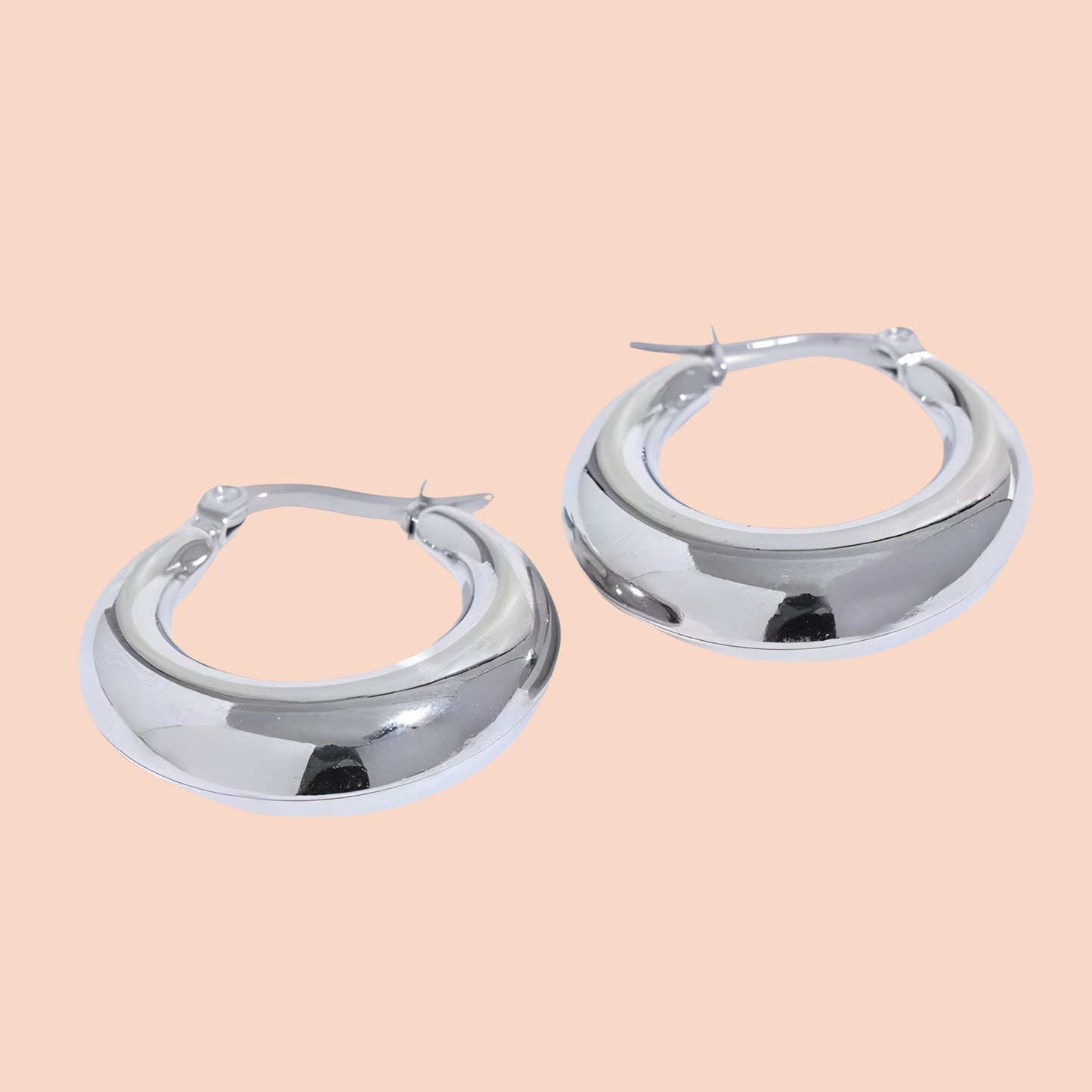 Pair of silver hoop earrings on a beige background