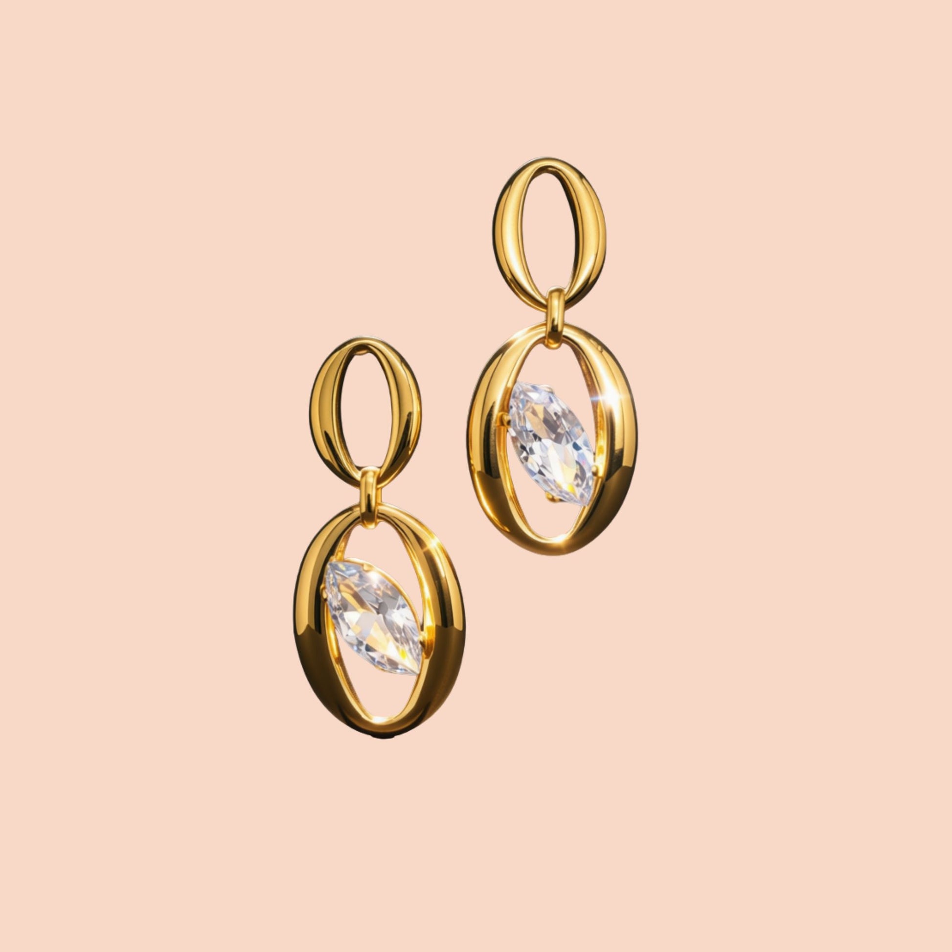 Gold earrings with clear gemstones on a beige background