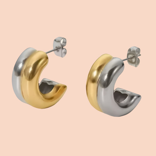 Mixed metal gold and silver earring on a pink background