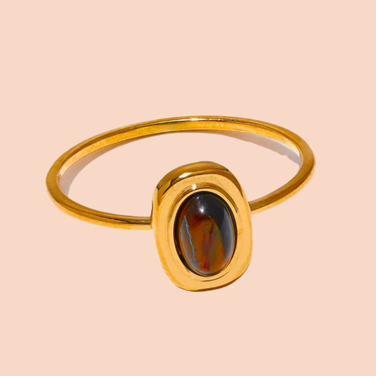Gold ring with a gemstone on a beige background