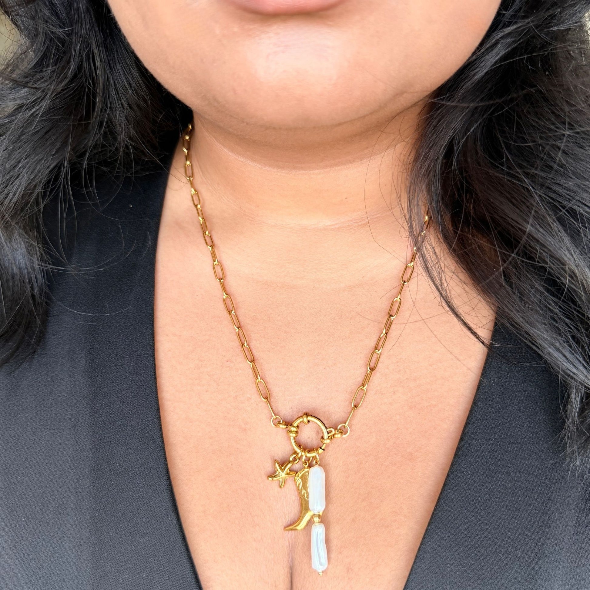 Gold necklace with a moon and star pendant worn by a person