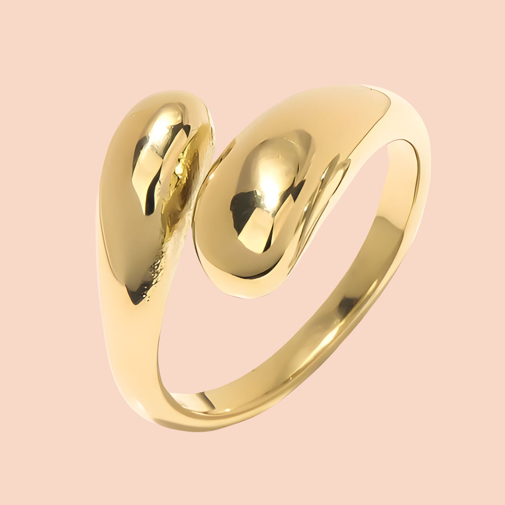 Gold ring with a unique design on a pink background